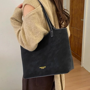 Grand sac cabas en cuir noir avec surpiqûres blanches contrastées dans un salon chic
