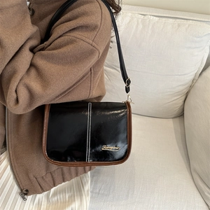 Retro black glossy leather shoulder bag for women with gold logo and brown trim detail