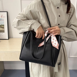 Minimalist black faux leather tote bag with polka dot scarf and chain handle for women