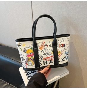 Close-up of a fashionable graffiti tote bag featuring artistic cartoon bear and shark prints