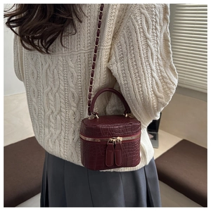 Dettaglio mini borsa a scatola bordeaux con trama coccodrillo e tracolla a catena oro