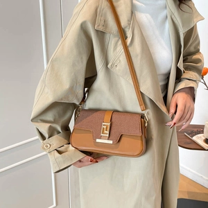 Chic brown patchwork square handbag with gold buckle and adjustable strap on a model