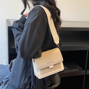 Minimalist beige crossbody bag with wide strap and three-layer accordion design