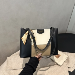 Detail of color-block leather tote bag featuring printed silk scarf and contrast stitching