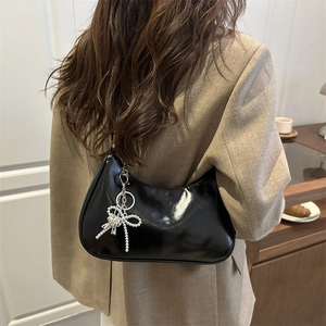 Minimalist black shiny leather underarm bag with silver beaded bow and heart charm details