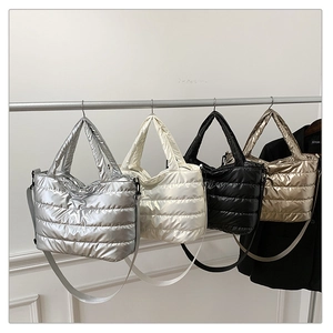 Quilted nylon tote bags in silver, white, black and gold colors displayed on a metal rack