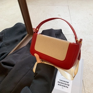 Detail view of contrast color baguette bag with red leather and beige mesh texture