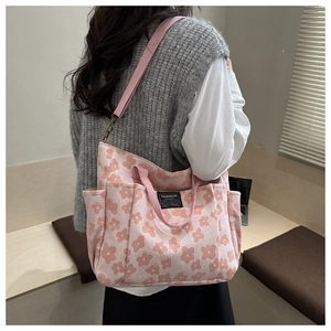 Detail of pink floral jacquard tote bag featuring flower patterns and side storage pockets