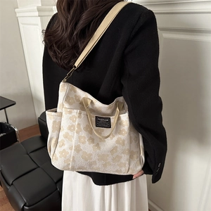 Minimalist beige canvas tote bag with floral patterns and adjustable shoulder strap