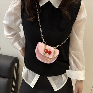 Pink saddle bag with cherry detail, gold thick chain handle, and thin crossbody strap