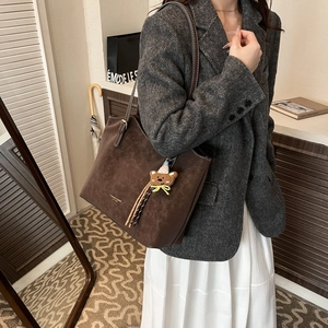 Large dark brown matte leather tote bag with a cute bear pendant for daily commuting