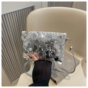 Détail du petit sac carré à paillettes argentées avec une fermeture éclair dorée chic