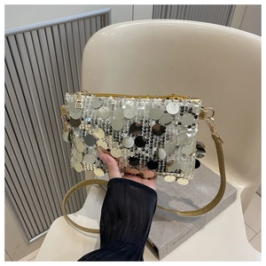 Détail de paillettes dorées et argentées sur un sac à bandoulière carré avec zip en métal