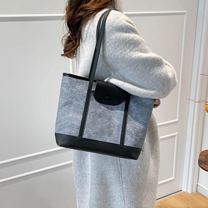 Minimalist grey felt tote bag with black leather trim and long shoulder straps for women