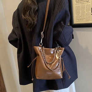 Sac seau chic en cuir huilé marron avec bandoulière chaîne et fermeture par cordon