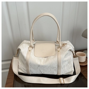 Detail of a beige quilted pillow bag with HUAJIAO FASHION logo and golden hardware