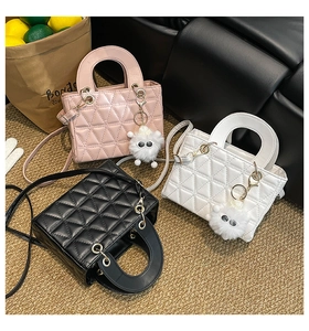 Trois sacs bandoulière matelassés en rose, blanc et noir avec un charm peluche