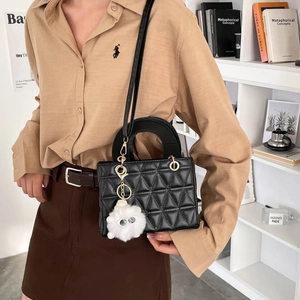 Sac à main noir matelassé avec charm monstre chic et bandoulière amovible