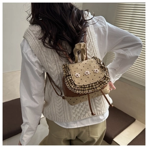 Detail of vintage polka dot mini backpack featuring decorative white knitted flowers
