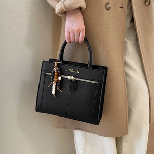 Vintage black leather tote bag with gold lettering and wooden bead charm accessory