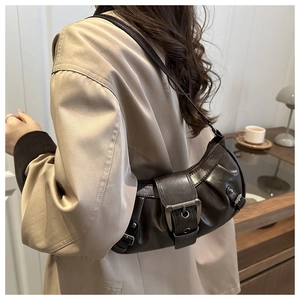 Detail of dark brown leather underarm bag with vintage pleats and large metal buckle