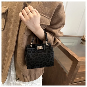 Détail du sac seau à imprimé léopard avec fermoir pivotant doré et texture mate
