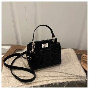 Détail du sac noir à motif léopard avec fermoir doré et bandoulière amovible