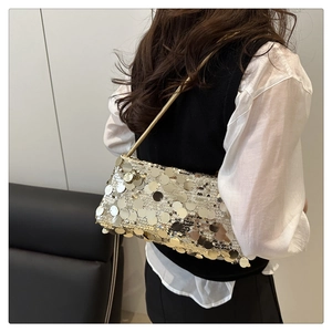 Detailansicht einer goldenen Pailletten-Schultertasche mit dünnen Metallgriffen für Abende