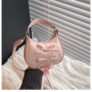 Detailed shot of pink moon bag with bow accents and silver metal zipper details