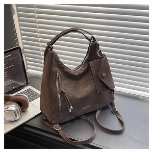 Détail du sac cabas marron foncé avec fermeture à pompon et petite pochette assortie