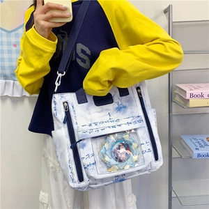 White canvas ita bag with blue calligraphy, clear window and badges for students