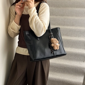 Minimalist black leather tote bag with a cute brown bear charm for women's office look