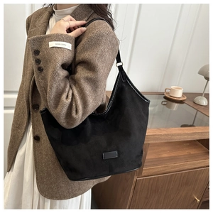 Détail du sac hobo en daim noir minimaliste avec bordure en cuir et boucle en métal