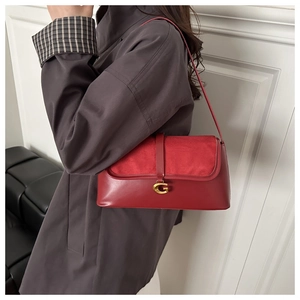 Detail of red leather crossbody bag with golden G-buckle and premium suede texture