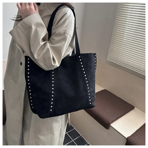 Vue détaillée du grand sac cabas vintage noir avec clous argentés sur tissu texturé