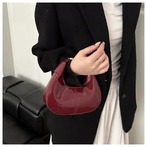 Vue détaillée du sac hobo croissant en cuir verni rouge vin brillant avec surface réfléchissante