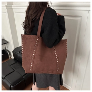 Détail d'un grand sac cabas en daim marron avec rivets rétro et doubles bandoulières
