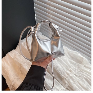 Detail view of metallic silver handbag with HYLLZZA logo and sleek handle design