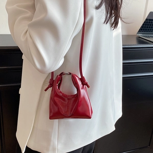 Chic red patent leather handbag with semi-circular metal handle for modern crossbody use