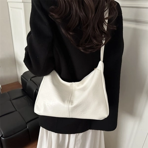 Minimalistische weiße Leder-Hobo-Tasche am Modell für einen modernen Pendlerstil
