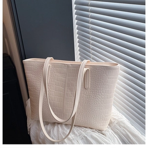 Close-up of cream crocodile pattern tote bag showing elegant texture and sturdy handles