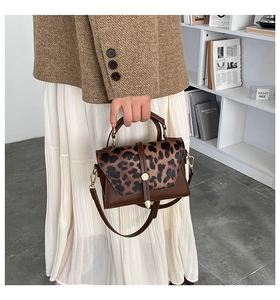Détail du sac à main en cuir marron et imprimé léopard avec quincaillerie dorée