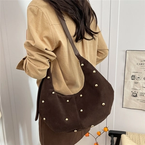 Borsa hobo in pelle scamosciata marrone con borchie dorate indossata dal modello