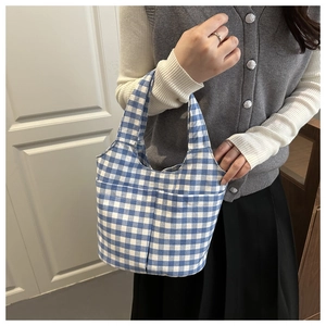 Detail shot of blue and white checkered canvas tote bag with functional front dual pockets