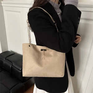 Sac fourre-tout beige minimaliste avec chaîne dorée et pendentif cerf sur un mannequin