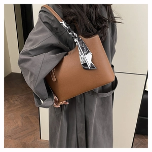 Brown litchi grain tote bag with decorative patterned silk scarf detail on shoulder strap