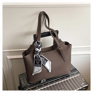 Macro detail of dark brown litchi grain tote bag with printed silk scarf on handle