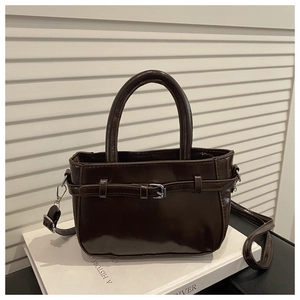 Détails macro d'un sac à main rétro marron foncé avec finition brillante et poignée