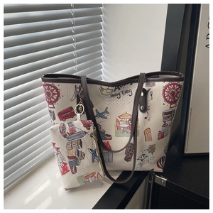 Detail of a white tote bag with travel graffiti prints and a matching small pouch charm