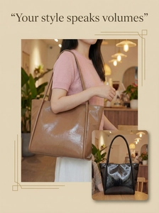 Detail of glossy patent leather tote bag in khaki and black with shiny reflective texture